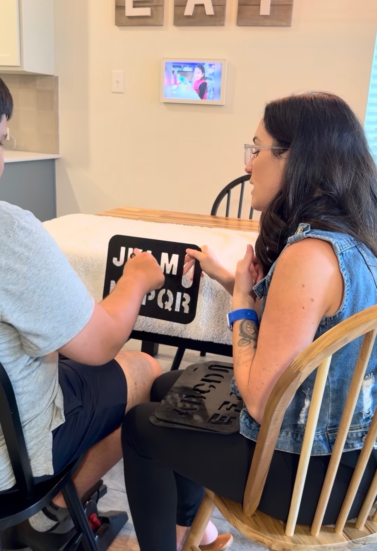 Sunny spelling with a student using a letterboard